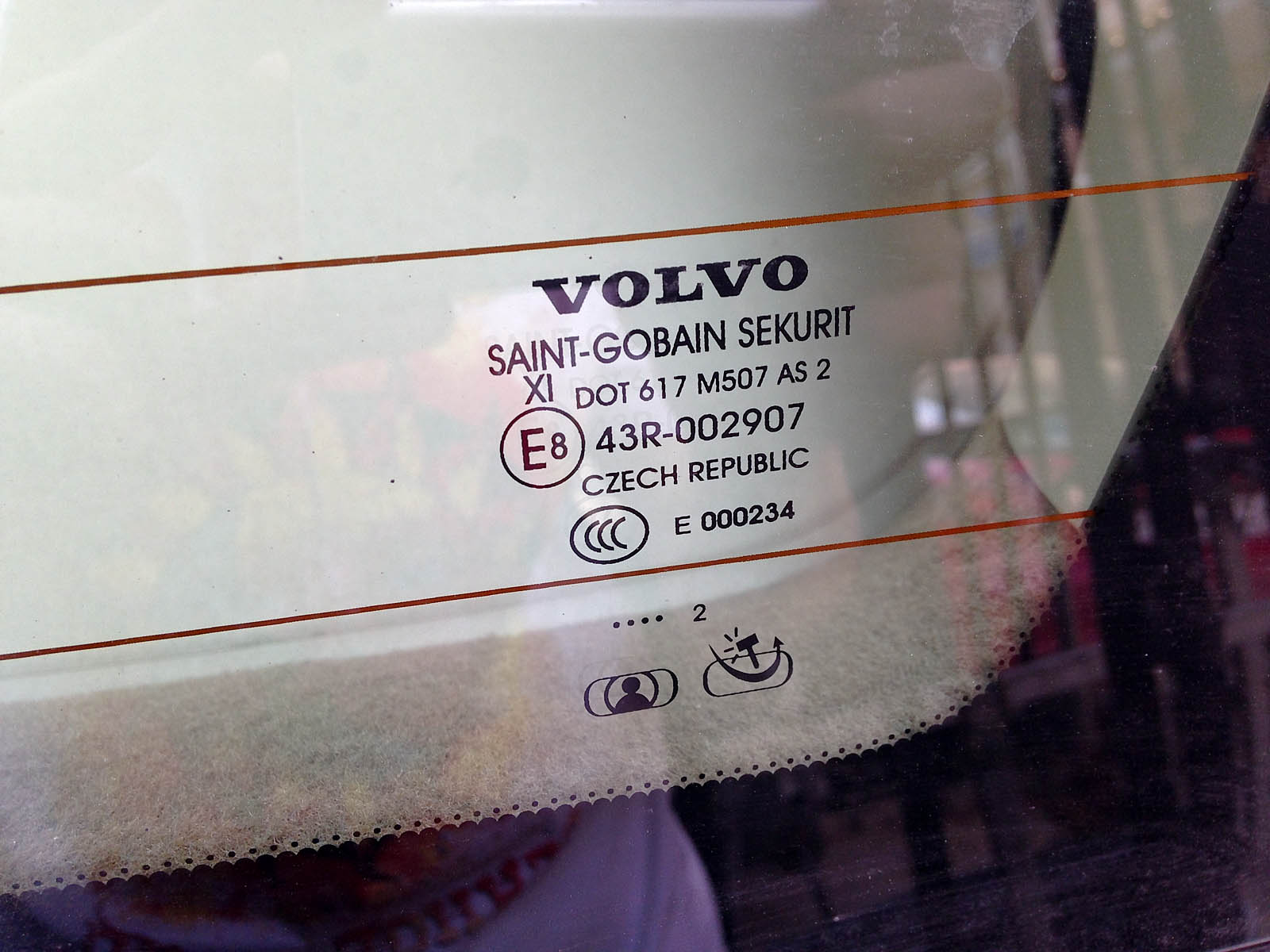 На стекле присутствует марка авто, название производителя и год изготовления.